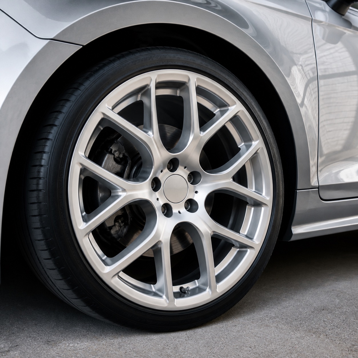 A close view of a clean silver alloy wheel and carefully finished tyre